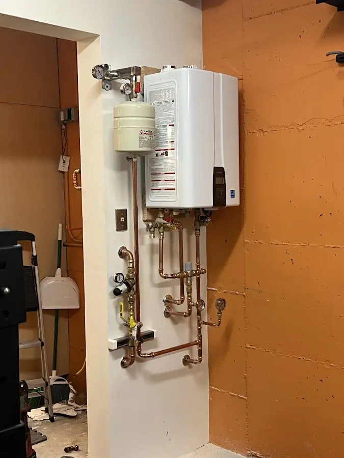 Plumbing technician inspecting water heater connections in Bryant
